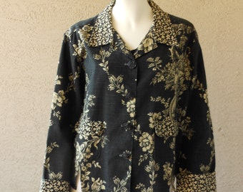 May include: A black floral patterned jacket with a collared neckline and button closure. The jacket has a gold floral pattern and a contrasting gold collar.