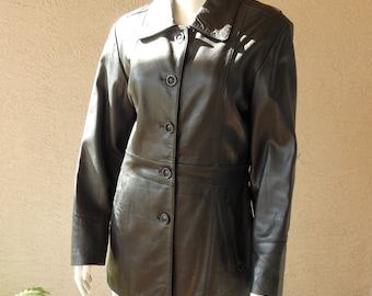 May include: A black leather jacket with a button-up front, a collared neckline, and long sleeves. The jacket has a tailored fit and a classic design, suitable for various occasions. The jacket is displayed on a mannequin.