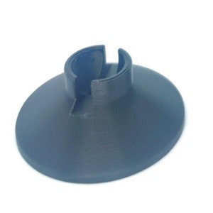 May include: A black plastic stand with a circular base and a center opening. The stand is designed to hold a small object, such as a phone or a candle.