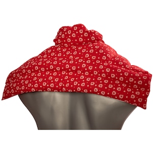 Könnte beinhalten: Roter Stoff-Halswickel mit einem weißen Herzmuster. Der Wickel ist so konzipiert, dass er um Hals und Schultern getragen werden kann.