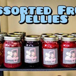 Può includere: Assortimento di gelatine di frutta in vasetti di vetro con etichette che recitano "William's Preserves". I vasetti sono disposti su uno scaffale nero.