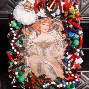 May include: A Christmas-themed picture frame decorated with red, green, and white beads, puzzle pieces, and a Santa Claus figure. The frame features a vintage image of a woman in a white dress.
