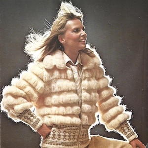 Puede incluir: Chaqueta de punto crema, con costuras horizontales y cierre de cremallera. La chaqueta presenta un cuello redondo y puños con un diseño estampado. Las mangas son abullonadas y el estilo general recuerda a la moda vintage.