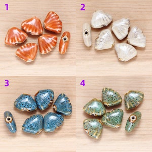 May include: Assortment of ceramic triangle-shaped beads in four different colors: orange, white, blue, and green. The beads have a textured surface and a hole in the center for stringing.