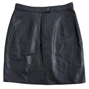 May include: A black leather skirt with a button closure at the waistband. The skirt has a classic A-line silhouette and a textured surface. The skirt is a versatile piece for any wardrobe.