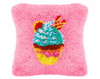 May include: A pink pillow with a colorful cupcake design embroidered on the front. The cupcake is decorated with sprinkles, frosting, and a cherry on top.