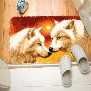 May include: A rug with a colorful sunset background and two white wolves with their heads touching. The rug is made of looped yarn and has a fuzzy texture.