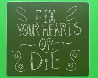 May include: A square, dark green sticker with white text that reads "FIX YOUR HEARTS OR DIE". The text is in a decorative, handwritten style. The sticker is on a bright green background.