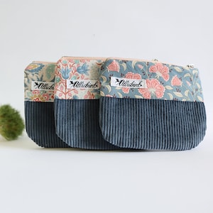 Könnte beinhalten: Drei kleine Reißverschlusstaschen mit floralen Mustern in Rosa, Blau und Creme auf der Oberseite und dunkelblauem Cord auf der Unterseite. Jede Tasche hat ein Etikett mit dem Text "Allisbird".