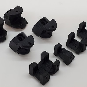 May include: Eight black plastic corner brackets, some with a rounded edge and others with a square edge.
