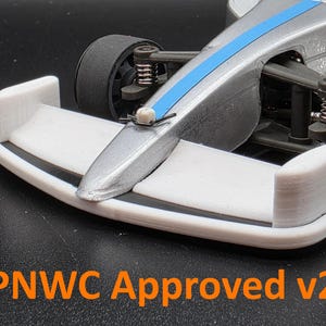 Könnte beinhalten: Ein silbernes und blaues Rennwagenmodell mit einem weißen Frontflügel. Das Modell hat schwarze Reifen und sichtbare Federungskomponenten. Der Text "PNWC Approved v2" ist unten im Bild in Orange gedruckt.