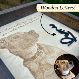 Könnte beinhalten: Ein gerahmtes Wandbild aus Holz mit einem lasergravierten Porträt eines Hundes mit Halsband, begleitet von dem Text "we alone could have kept you here, you would have lived forever" und einem dunkelblauen Namensschriftzug aus Holz.