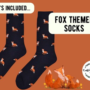 May include: A pair of dark navy blue socks featuring a repeating pattern of small orange and white foxes. The image includes text that reads WHAT'S INCLUDED and FOX THEMED SOCKS, along with a circular logo for Customise crazy and a fox illustration.