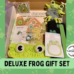 May include: A Deluxe Frog Gift Set in a box, including a plush frog, a colouring book, a headband, stickers, and a notepad. The set features a green headband with frog eyes, a plush frog toy, and a notepad with a frog design.