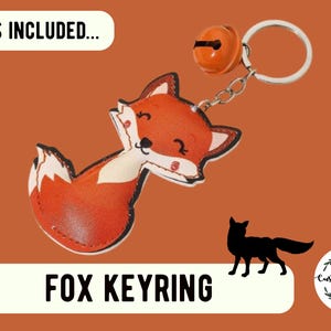 May include: A fox-shaped keyring featuring a cartoon fox with orange and white coloring, attached to a silver-toned metal ring and an orange jingle bell. The image includes the text WHAT'S INCLUDED and FOX KEYRING, plus a black fox silhouette.