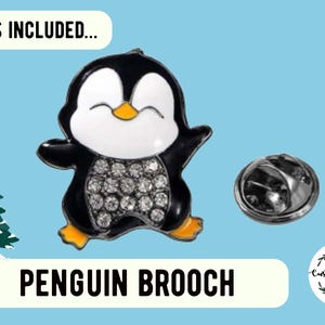 Puede incluir: Un broche de ping&uuml;ino negro y blanco con un cuerpo brillante. El broche est&aacute; unido a un alfiler de plata.