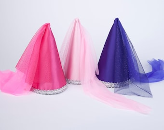 May include: Three cone-shaped party hats with tulle veils. The hats are pink, light pink, and purple. The veils are all pink.