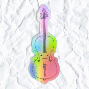 May include: A holographic cello sticker with a rainbow iridescent finish. The cello is outlined in black and has a white string detail.