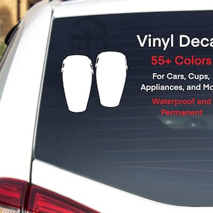 May include: A white vinyl decal of two conga drums on a black car window. The decal is waterproof and permanent. The text "Vinyl Decal 55+ Colors For Cars, Cups, Appliances, and More Waterproof and Permanent" is printed in red.