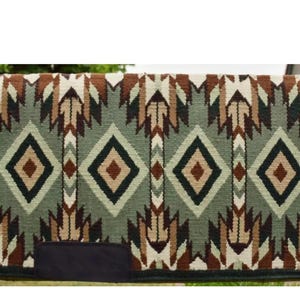 May include: A green, brown, and white woven saddle blanket with a geometric pattern. The blanket has a black patch on the bottom left corner.