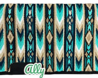 May include: A turquoise, green, brown, and white saddle pad with a geometric pattern. The saddle pad has a black border and the word "ally" in green letters on the bottom.
