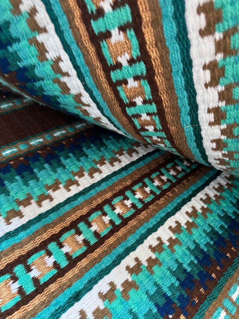 Pode incluir: Close-up de um tecido tecido com um padr&atilde;o repetitivo de listras marrons, brancas, azul-turquesa e verdes. O tecido tem um aspecto texturizado e tecido &agrave; m&atilde;o.