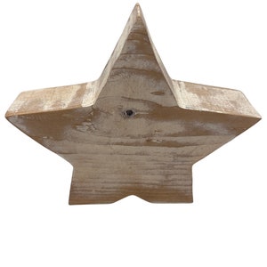 May include: A large, rustic wooden star with a distressed white paint finish. The star is made of natural wood and has a slightly uneven surface.