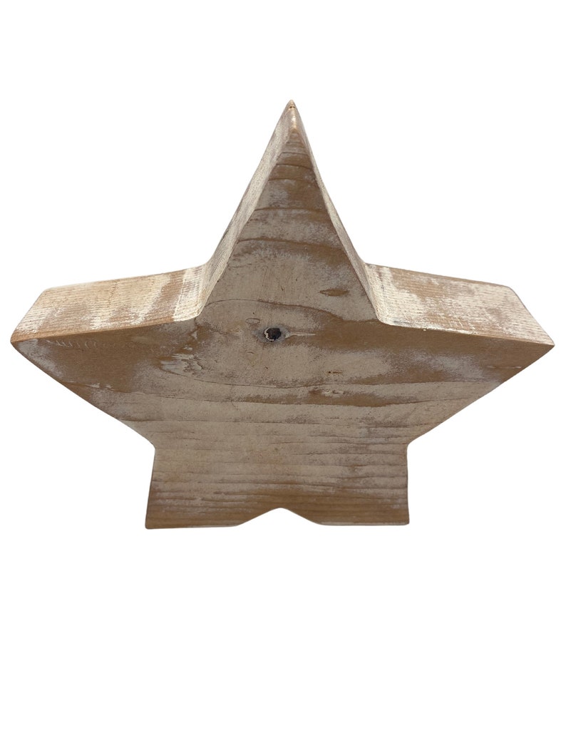 May include: A large, rustic wooden star with a distressed white paint finish. The star is made of natural wood and has a slightly uneven surface.