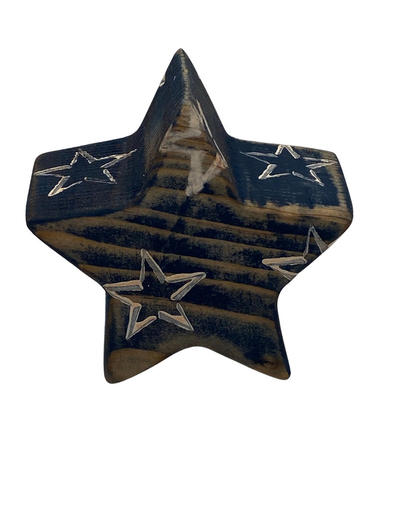 May include: A wooden star-shaped ornament painted in a dark blue color with white stars painted on the surface.