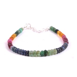 Könnte beinhalten: Ein mehrfarbiges Edelstein-Armband mit einem silbernen Verschluss. Das Armband zeigt einen Regenbogen an Farben, darunter Rot, Orange, Gelb, Grün, Blau und Lila.