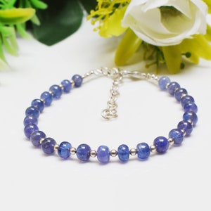 Può includere: Un braccialetto a catena d'argento con perline di pietre preziose blu. Il braccialetto ha una chiusura a moschettone.
