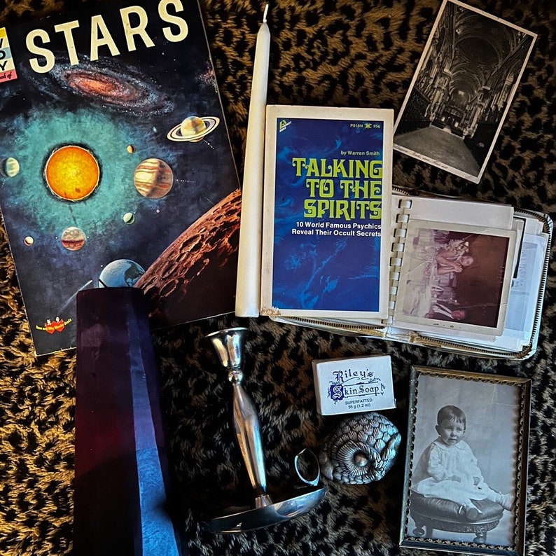 Antique mystery box, gothic style with oddities and creepy photos, occult book and candles.