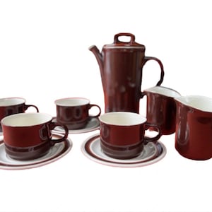May include: A brown and white ceramic tea set with a teapot, creamer, sugar bowl, and four cups and saucers.