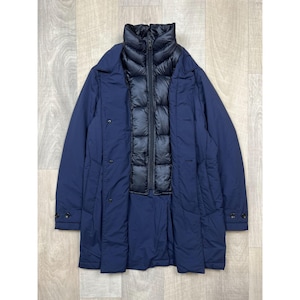 May include: A navy blue coat with a black quilted inner layer. The coat has a high collar, button closures, and a long, streamlined design. The outer layer is a smooth, solid color.
