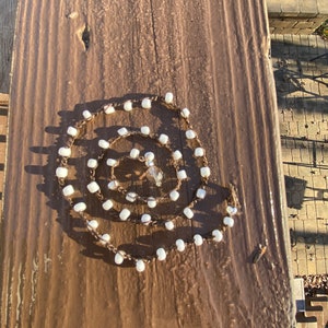 Handmade crocheted necklace with brown cord and white beads