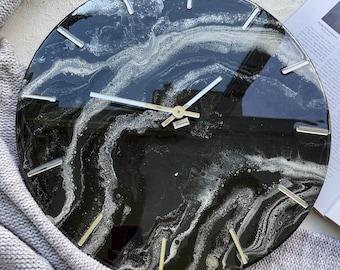 May include: Black and white abstract clock with silver hands and silver hour markers. The clock face has a marbled design.