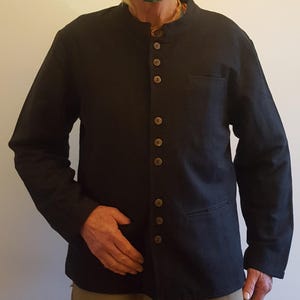 Può includere: Una camicia nera a maniche lunghe con colletto alla coreana e chiusura con bottoni sul davanti. La camicia ha una sola tasca sul lato sinistro ed è realizzata in un tessuto morbido e confortevole.