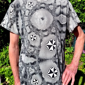 May include: A black and white t-shirt with a psychedelic pattern of swirling circles and stars.