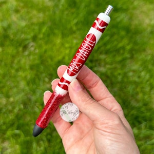 May include: Red and white glitter pen with the text "Mrs. Dagle" on it.