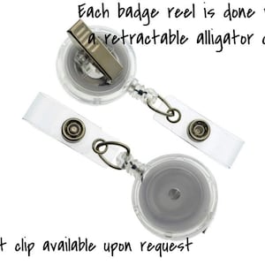 May include: Two clear plastic retractable badge reels with alligator clips. Each reel has a clear plastic strap with a metal button.