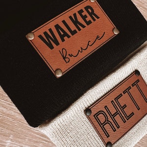 May include: Two brown leather patches with black text. The top patch says "WALKER Bruce" and the bottom patch says "RHETT".