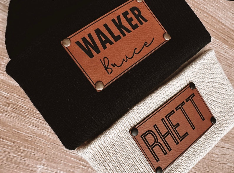 May include: Two brown leather patches with black text. The top patch says "WALKER Bruce" and the bottom patch says "RHETT".
