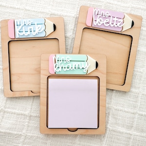 May include: Three wooden note holders with a pencil design and a sticky note pad. The pencils are decorated with the names "Mrs. Kirk", "Mrs. Khamy", and "Mrs. Boeltz".