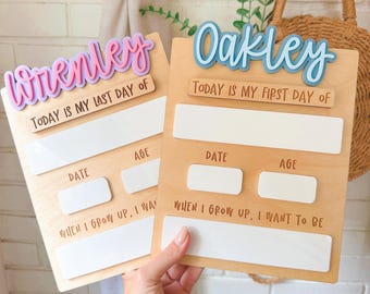May include: Two wooden school boards with the names "Wrenley" and "Oakley" in colorful lettering. Each board has space for "Date," "Age," and "When I Grow Up, I Want to Be." One board says "Today is my last day of," and the other says "Today is my first day of."