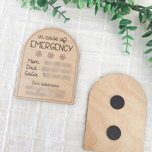 May include: Wooden arch-shaped sign with the text "in case of EMERGENCY" and spaces to write contact information for Mom, Dad, and Gaga, along with an address. The back of the sign has two black magnets.