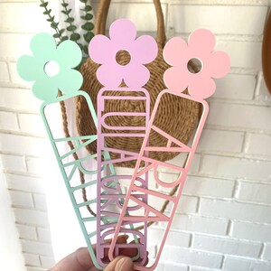 May include: Three colourful bookmarks with flower accents. Each bookmark features a different name: "Grace", "Ari", and "Kaylee".