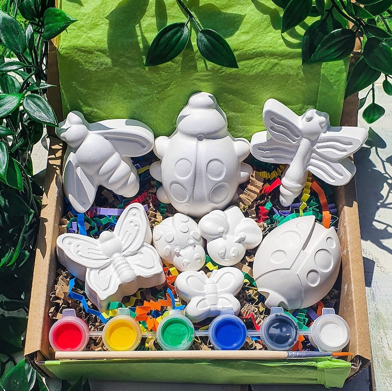 Puede incluir: Un conjunto de ocho figuritas de cer&aacute;mica blanca en forma de mariquita, mariposa y lib&eacute;lula en una caja de cart&oacute;n con botes de pintura y un pincel. Las figuritas est&aacute;n listas para ser pintadas.
