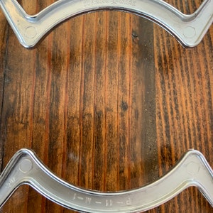 May include: Two silver metal stovetop burner rings with the text "CORNING WARE" and "P-11-M-J" on them.