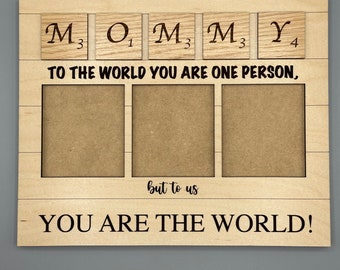 May include: Wooden photo frame with the words "To the world you are one person, but to us you are the world!" and the word "MOMMY" spelled out with letter tiles. The frame has three empty photo slots.