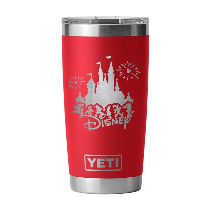 May include: A red insulated tumbler with a silver lid and base. The tumbler features a silver graphic of a castle, fireworks, and the word "Disney". The brand name "YETI" is displayed at the bottom.